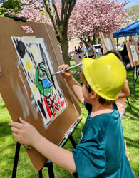 child with a hardhat painting in the park
