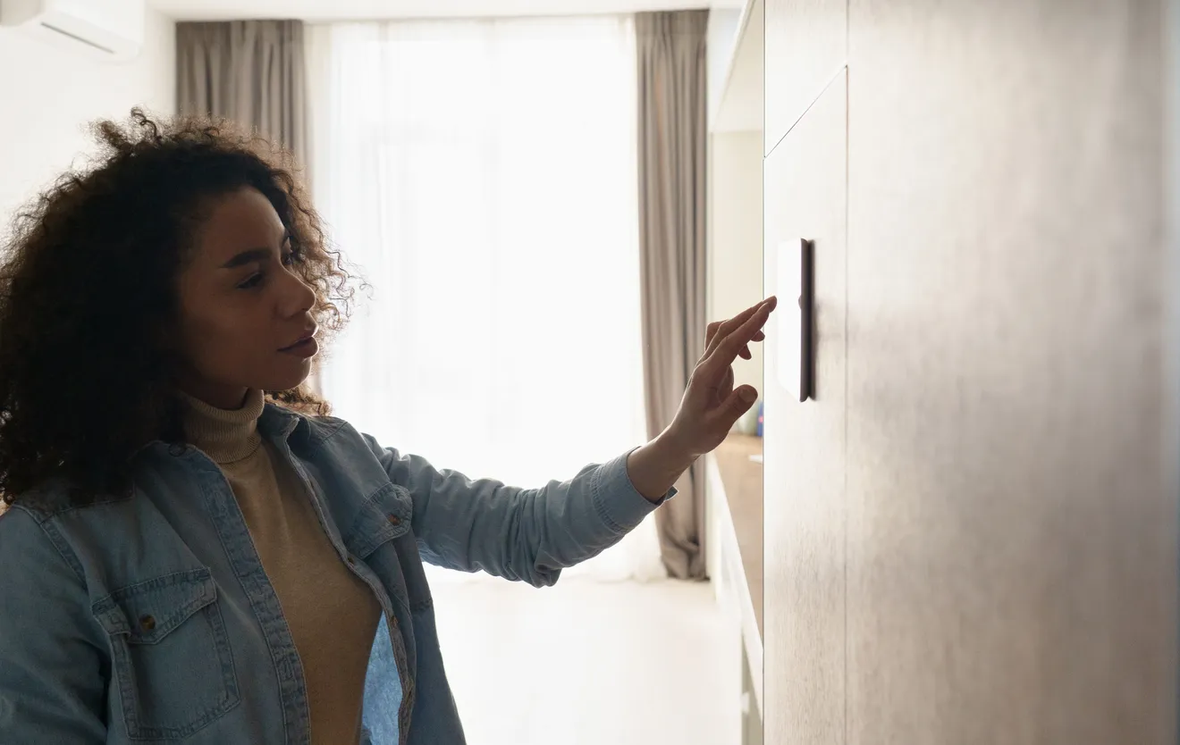 Woman checking the thermostat