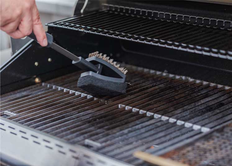 Closeup of a person cleaning the grill